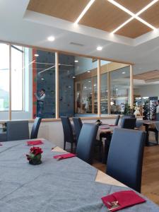 un ristorante con tavoli e sedie e una parete da arrampicata di Hotel Al Caminetto a Cembra