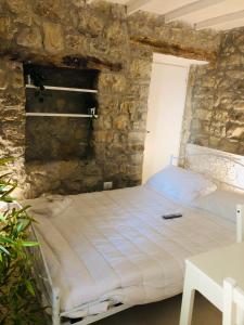 Cama en habitación con pared de piedra en Daiko Bed & breakfast, en Tornareccio