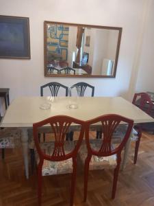 a dining room table with two chairs and a mirror at Retro Central in Thessaloniki