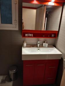 a bathroom with a red sink and a mirror at Retro Central in Thessaloniki