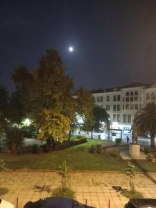 a view of a building at night with the moon at Retro Central in Thessaloniki