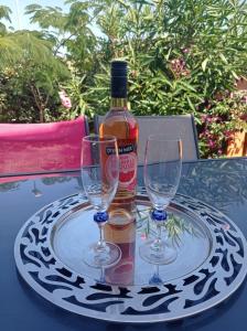 een fles wijn en twee wijnglazen op een tafel bij Appartement Cosy à Sanary Plage de Portissol-Climatisé-Parking privé in Sanary-sur-Mer
