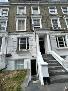 a building with stairs leading to the front door at Flat 1, 128A Belsize Road NW6 4BG LONDON in London