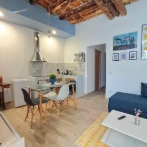 ein Wohnzimmer mit Esstisch und blauem Sofa in der Unterkunft PalermHost in Palermo