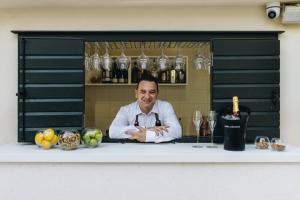 a chef standing behind a counter in a bar at Sperone Hotel in Split