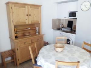 a kitchen with a table and a kitchen with a microwave at Les Iris , mazet 48 in Saint-Martin-de-Brômes