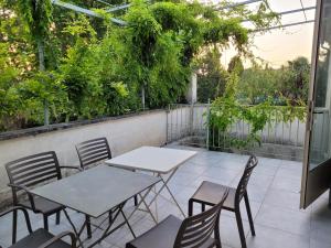 two tables and chairs on a patio with plants at Cécile - Mas de Rousseau in Eyragues