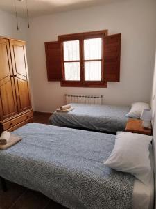 two beds in a room with two windows at Molino Viejo, Jauca Baja, 04899 El Hijate, Almeria Province Spain in El Hijate