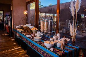 a buffet table with plates and bowls of food on it at Hotel Cumbres San Pedro de Atacama in San Pedro de Atacama