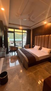 - une chambre avec un grand lit et une grande fenêtre dans l'établissement HOG - House of Gypsy, à Rishikesh