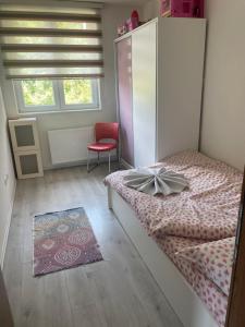 ein Schlafzimmer mit einem Bett, einem Stuhl und einem Fenster in der Unterkunft LUX Villa Mavrovo in Mavrovo-Nationalpark