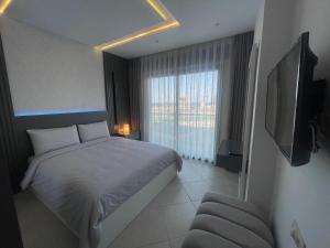 - une chambre avec un lit, une télévision et une chaise dans l'établissement Al amirat martil luxury, à Martil