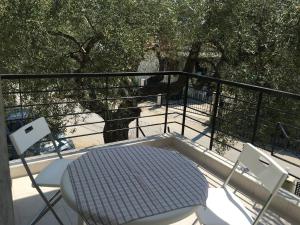 einen Tisch und Stühle auf einem Balkon mit Bäumen in der Unterkunft Spacious Apartment Skala Fourkas in Skála Foúrkas