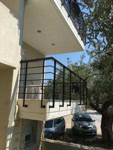 einen Balkon an der Seite eines Hauses mit Auto in der Unterkunft Spacious Apartment Skala Fourkas in Skála Foúrkas