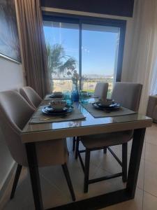 a dining room table with chairs and a large window at Al amirat martil luxury only family in Martil