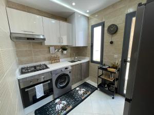 a small kitchen with a stove and a sink at Al amirat martil luxury only family in Martil +10 photos