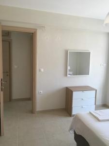 ein Schlafzimmer mit einem Bett, einer Kommode und einem Spiegel in der Unterkunft Spacious Apartment Skala Fourkas in Skála Foúrkas