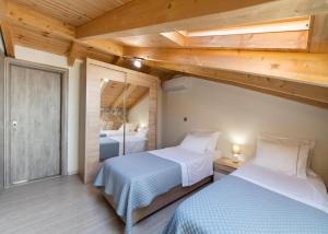 a bedroom with two beds in a room with wooden ceilings at Stamatina by Vintage Travel in Meganisi +26 photos