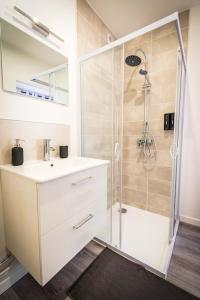 a white bathroom with a shower and a sink at L'Albatros 007 - Hypercentre * Cosy * Wifi in Saint-Quentin