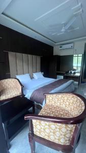 1 Schlafzimmer mit einem großen Bett und 2 Stühlen in der Unterkunft HOG - House of Gypsy in Rishikesh