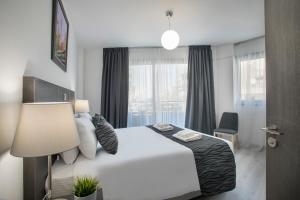 a bedroom with a bed and a lamp and a window at Blazer Residence in Larnaca