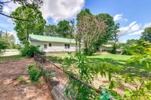 a house with a fence in front of a yard at Jonesboro Retreat Near Arkansas State University! in Jonesboro