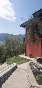 a walkway next to a red building with a view at Agriturismo Cascina Lert in Marone