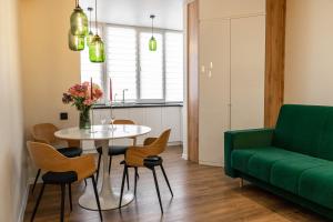 a living room with a table and a green couch at Apartment 5 star CENTER in Vinnytsya