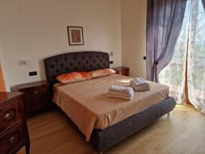 a bedroom with a bed with two towels on it at Nataly in SantʼAmbrogio di Valpolicella