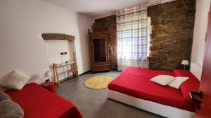 a bedroom with a red bed and a stone wall at Comfort Accommodation Residence in Bergamo