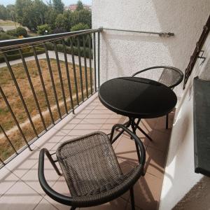 a patio with a table and a chair on a balcony at Ana 2 Duży przestronny apartament z 2 balkonami Wi-Fi Netflix Idealny dla rodzin z dziećmi in Gorzów Wielkopolski