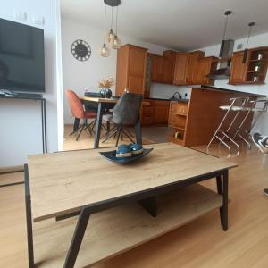 uma cozinha e sala de jantar com uma mesa de madeira com um prato em Ana 2 Duży przestronny apartament z 2 balkonami Wi-Fi Netflix Idealny dla rodzin z dziećmi em Gorzów Wielkopolski
