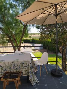 a table and chairs under an umbrella on a patio at La Zagala in Badajoz