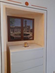 une étagère dans une chambre avec fenêtre dans l'établissement AFFITTACAMERE SANT'ANGELO, à Abbadia San Salvatore