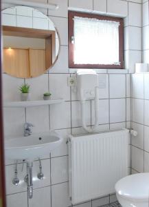 a white bathroom with a sink and a mirror at Pension Haus Bambi in Mölln