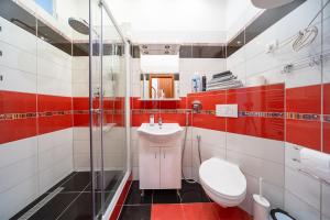 a red and white bathroom with a toilet and a sink at Apartment Amélie in Karlovy Vary +25 photos