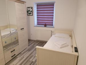 um pequeno quarto com uma cama e um espelho em Luxury Apartments em Selimbar