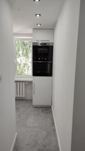 a kitchen with a white refrigerator and a window at APARTAMENT "Opawska Przystań" in Głuchołazy
