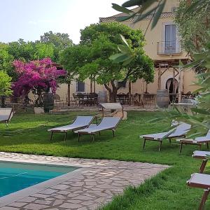 a group of benches sitting in the grass next to a house at Masseria Procacci in Ischitella