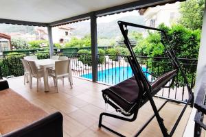 d'un balcon avec une table, des chaises et une piscine. dans l'établissement Arslan Villa with Pool, à Marmaris