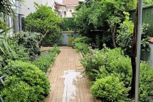 ogród z drewnianym chodnikiem z drzewami i krzakami w obiekcie Arslan Villa with Pool w mieście Marmaris