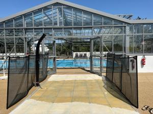 een groot glazen gebouw met een zwembad bij Le COTTAGE Baulois-Entre MER et NATURE- Plages- Tout à vélo ou à pied- PISCINE couverte in Guérande