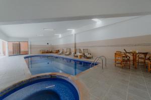- une grande piscine dans une pièce avec une table dans l'établissement Hotel Hacienda La Cieneguita, à San Miguel de Allende