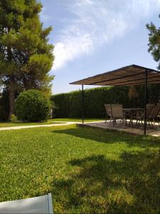 a picnic table and chairs under a canopy in a park at La Zagala in Badajoz