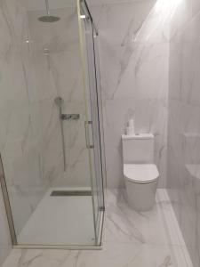 La salle de bains blanche est pourvue d'une douche et de toilettes. dans l'établissement Heart of Lisbon - Bica Apartamentos, à Lisbonne