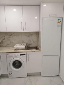 - une cuisine avec des placards blancs et un lave-linge dans l'établissement Heart of Lisbon - Bica Apartamentos, à Lisbonne