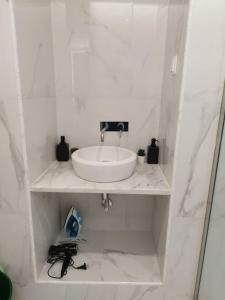 La salle de bains blanche est pourvue d'un lavabo et d'un miroir. dans l'établissement Heart of Lisbon - Bica Apartamentos, à Lisbonne