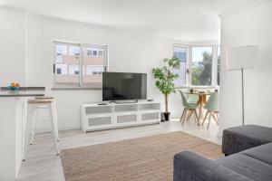 a living room with a flat screen tv on a cabinet at Bright Algés Apartment by Lisbeyond in Algés