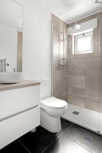 uma casa de banho com um WC, um lavatório e um chuveiro em Bright Alges Apartment em Algés