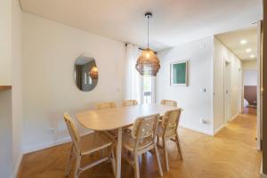 - une salle à manger avec une table et des chaises en bois dans l'établissement Olala Ribeira Apartment, à Cascais